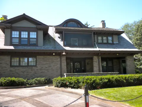 A brick and stucco house with a trimmed hedge in Omaha's Dundee neighborhood