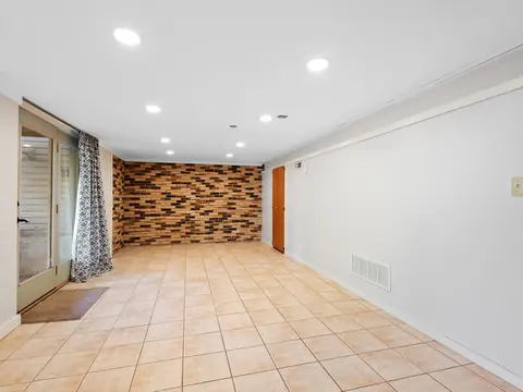 A bright, empty basement room with a tile floor