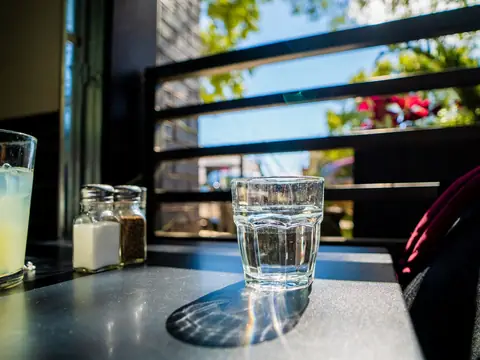 A glass of water on a sunlit table