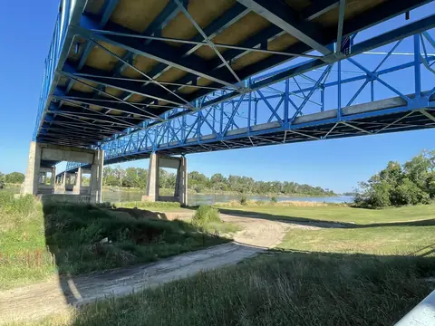 The Missouri River bank under the blue steel Mormon Bridge in north Omaha on a sunny day