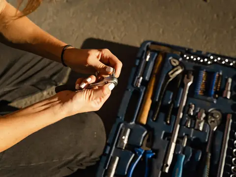 Hands picking a tool from an open case of wrenches and sockets