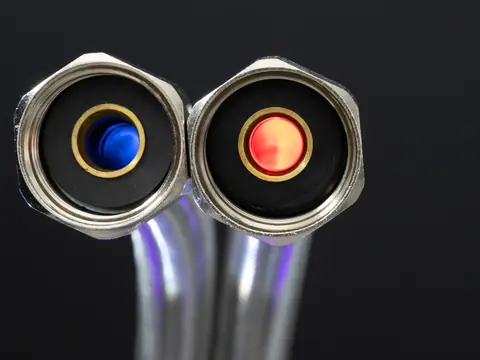 Two hose connectors marked blue for cold and red for hot, close up