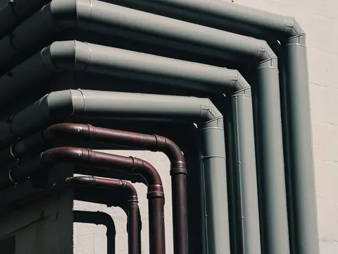 Painted water pipes bending along an outside wall